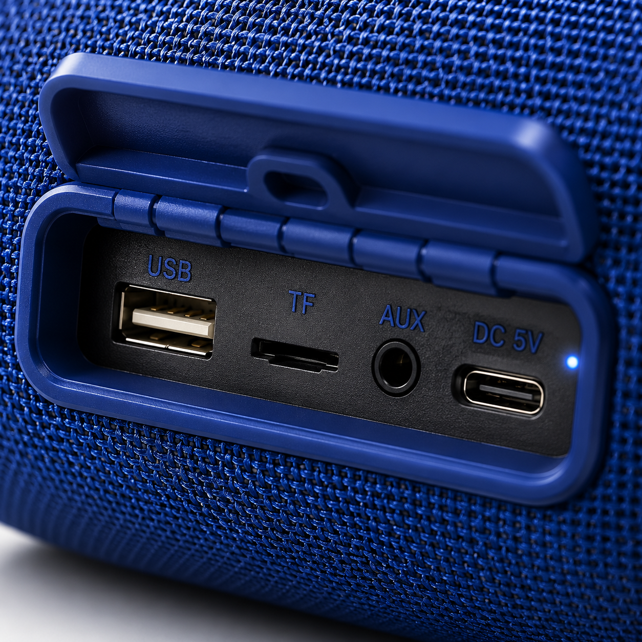 Close-up macro view of the portable Bluetooth speaker control panel with tactile media buttons, volume controls, play/pause, mode button, and durable textured fabric finish.