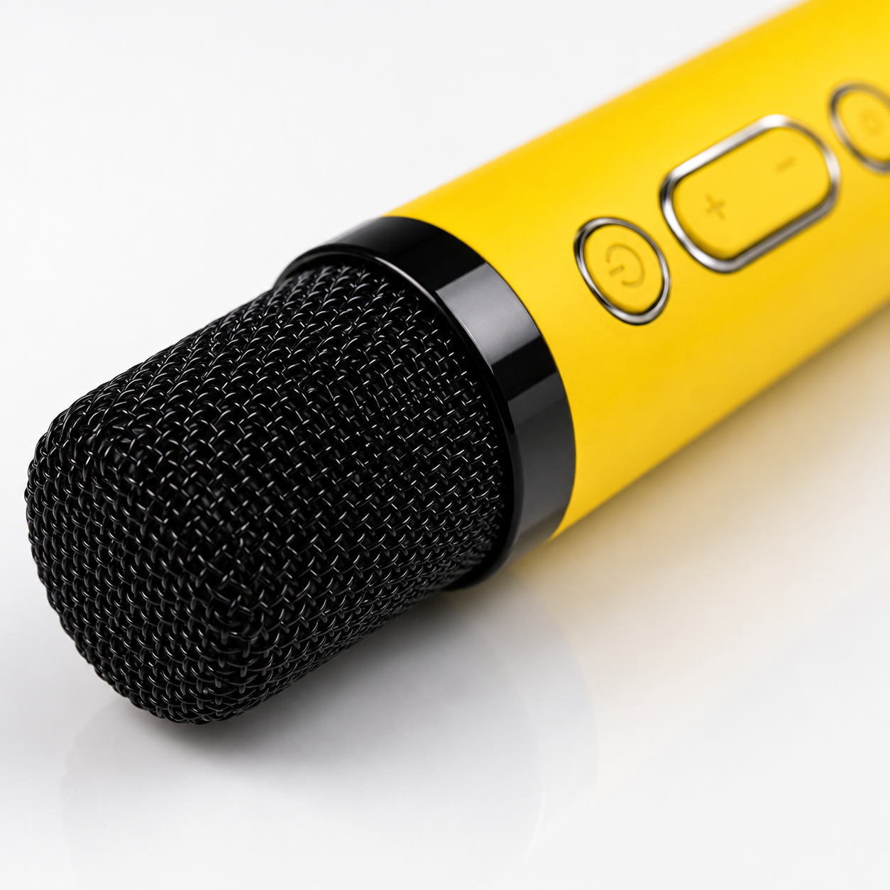 Close-up of the yellow wireless karaoke microphone with black metal grille, integrated power and volume buttons, ergonomic design and premium finish for clear voice performance.