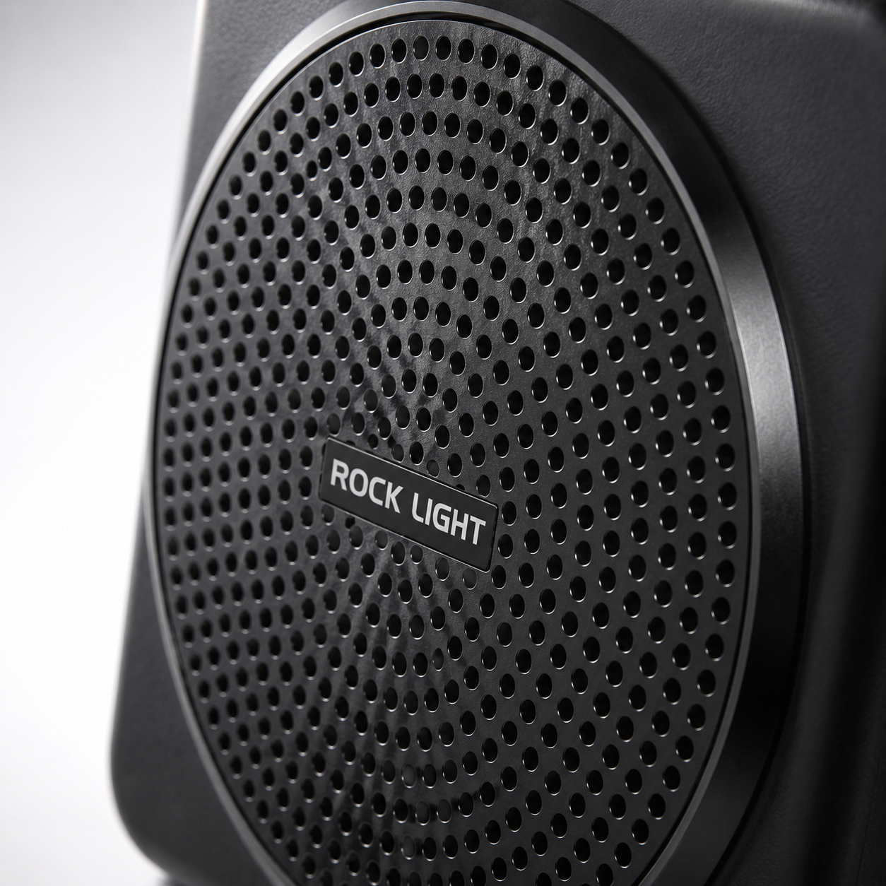 Close-up of a portable wireless voice amplifier featuring a perforated front speaker grille with a durable matte black finish, designed to deliver clear and powerful sound for teaching, presentations, and public speaking.