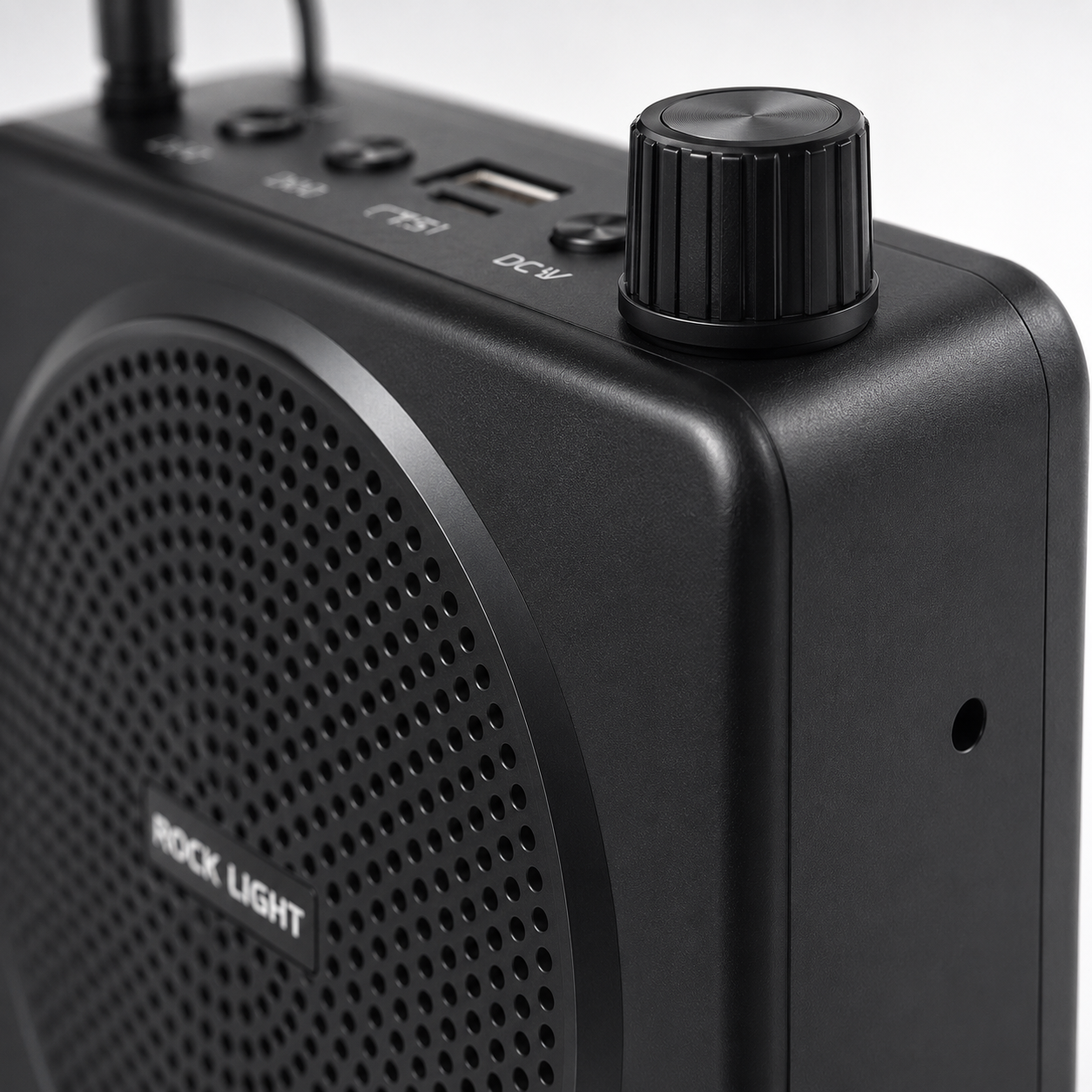 Detailed side view of a rechargeable voice amplifier showing the top-mounted volume control knob, USB charging port, TF card slot, control buttons, and headset microphone connection on a compact black ABS body.