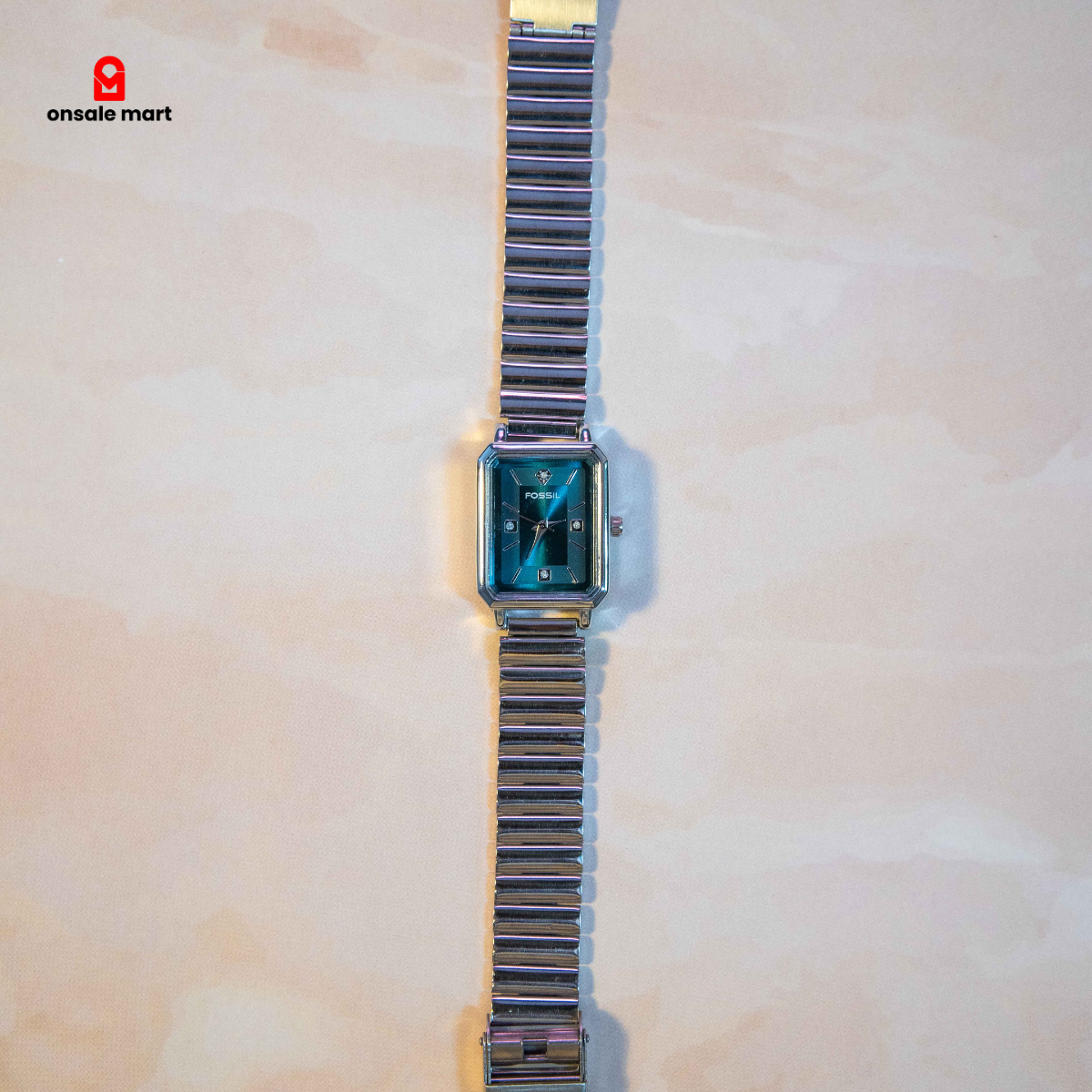 Rectangular steel watch with teal dial and stainless steel expansion bracelet.