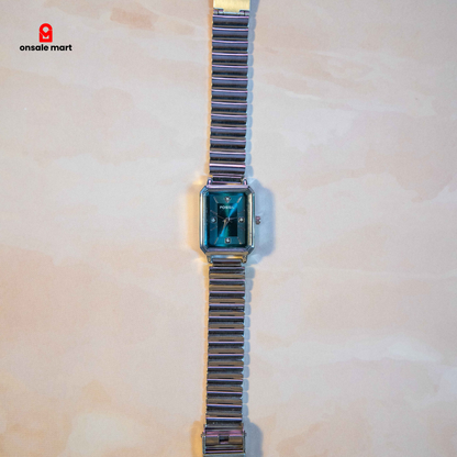 Rectangular steel watch with teal dial and stainless steel expansion bracelet.