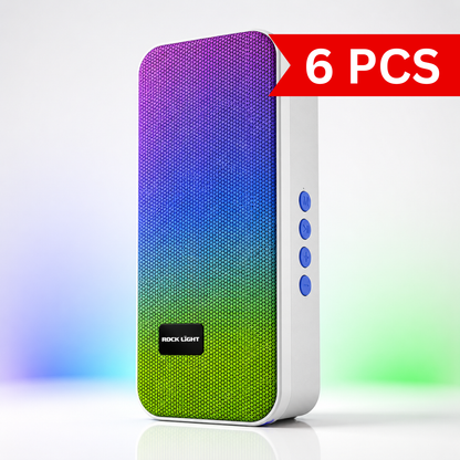 Front three-quarter view of the Rock Light Gleam S536 wireless Bluetooth speaker featuring a colourful purple-to-green fabric grille, white ABS body, compact portable design, and side-mounted control buttons