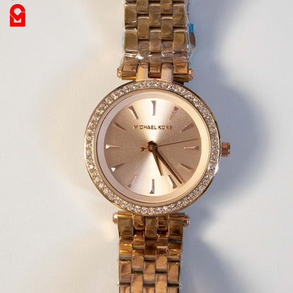 Close-up of rose gold ladies watch dial with crystal bezel and elegant minimalist design.