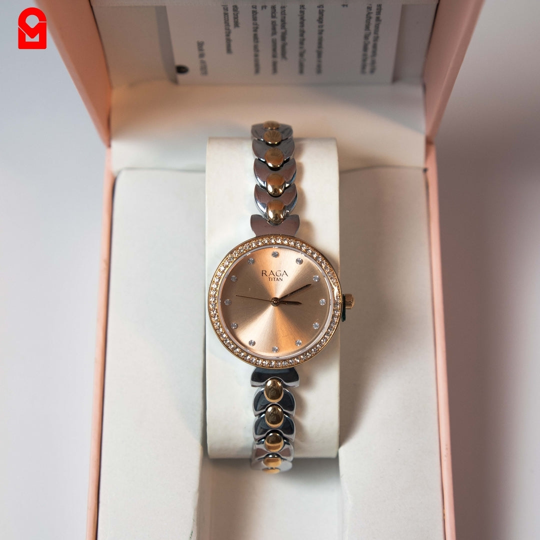 Women’s rose gold dial bracelet watch with crystal bezel displayed inside watch box.