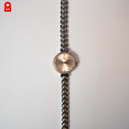 Rose gold dial women’s bracelet watch with crystal hour markers on white background.