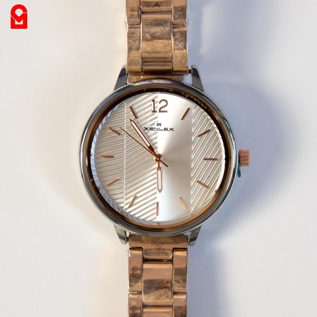 Close-up of women’s analog rose gold dial watch with stainless steel bracelet strap.