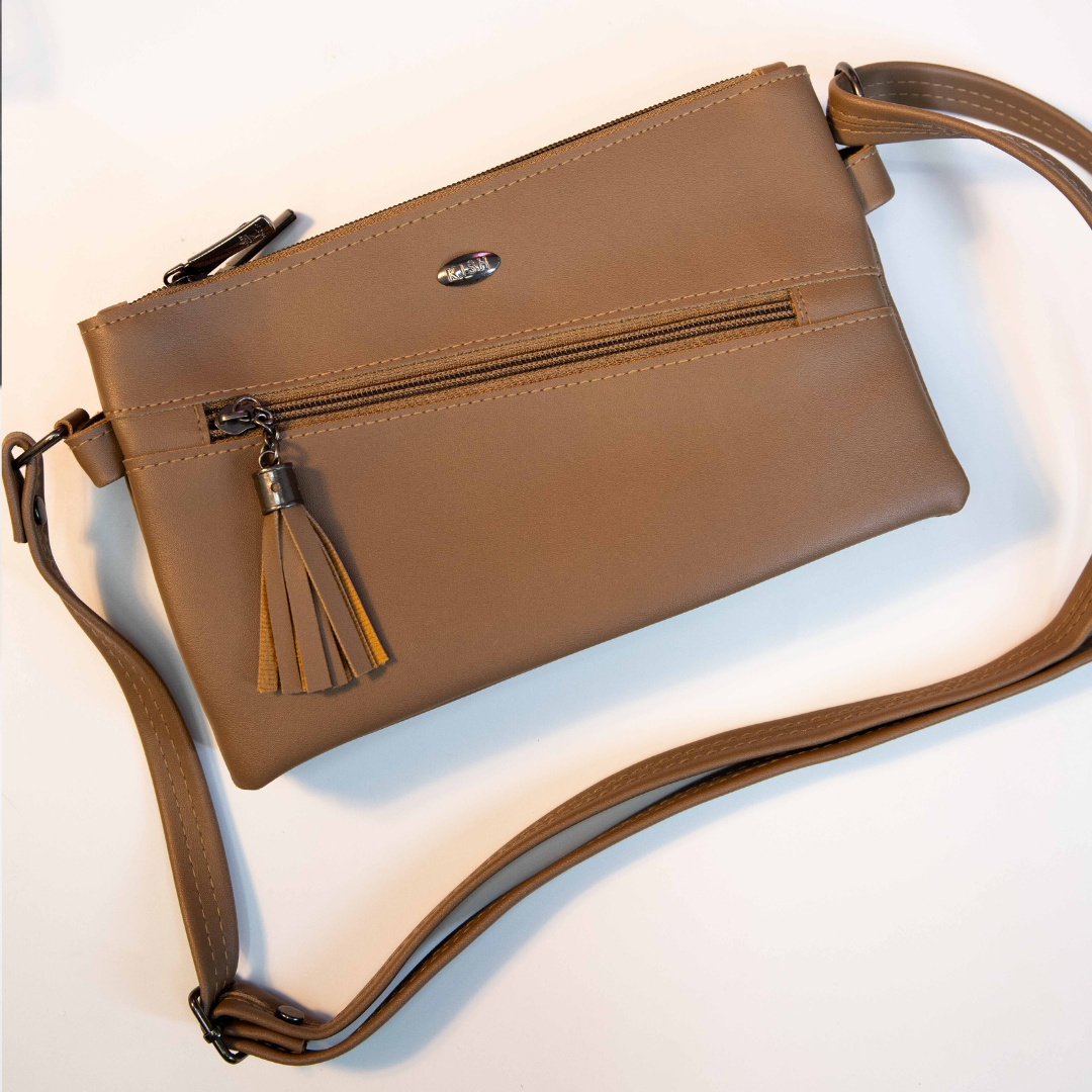 Tan compact sling bag with front zip pocket and tassel detail.