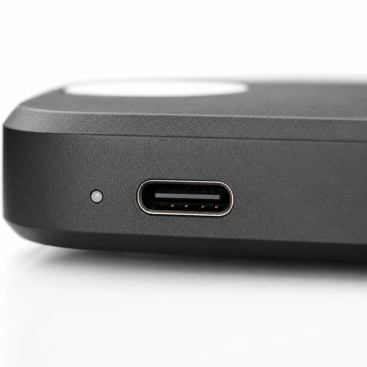 Macro close-up of the wireless earbuds charging case featuring a USB Type-C charging port and LED status indicator, showcasing the matte black finish, precise construction, and modern fast-charging design.