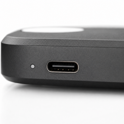Macro close-up of the wireless earbuds charging case featuring a USB Type-C charging port and LED status indicator, showcasing the matte black finish, precise construction, and modern fast-charging design.