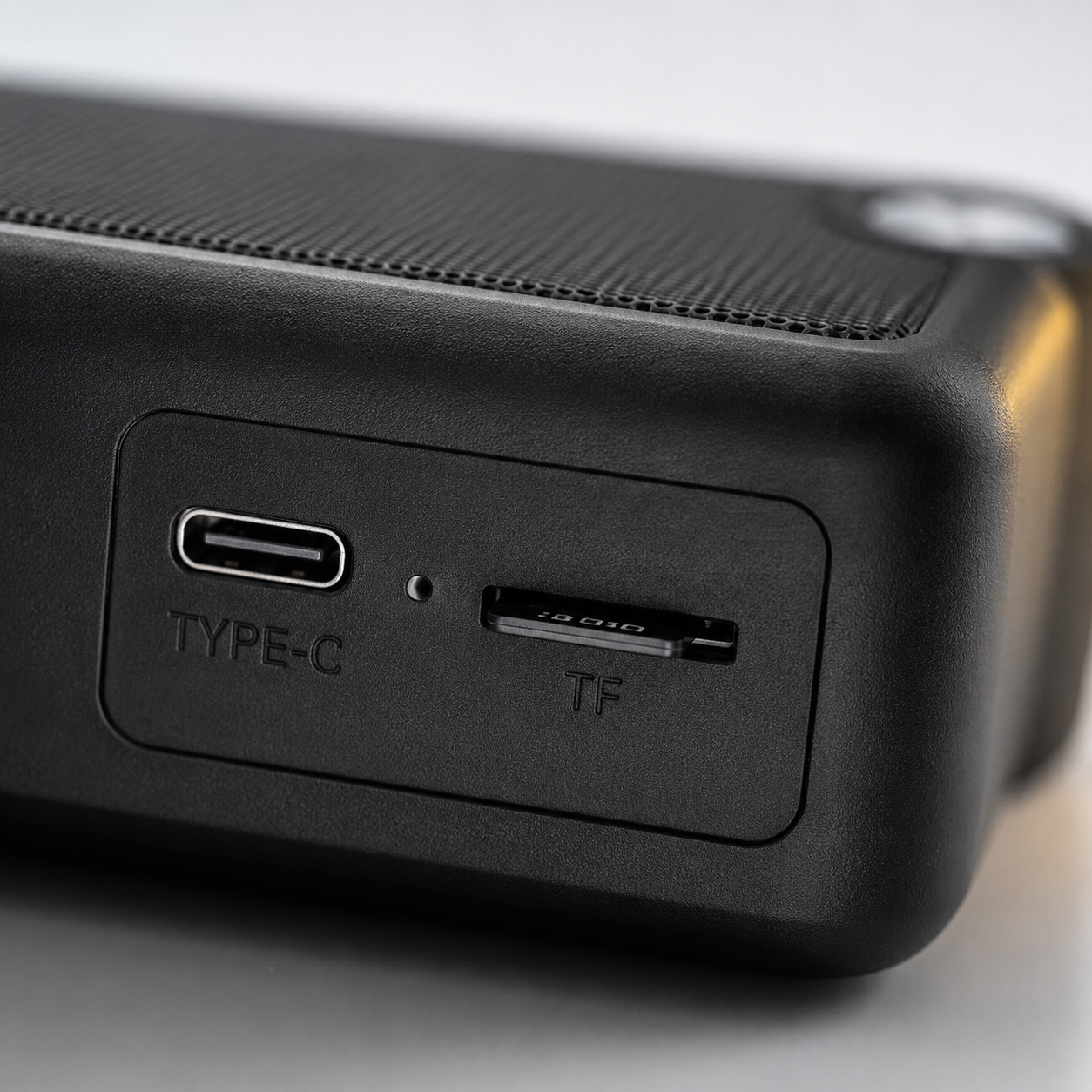 Macro close-up of the portable Bluetooth speaker showing the USB Type-C charging port and TF card slot for convenient charging and direct music playback from memory cards.