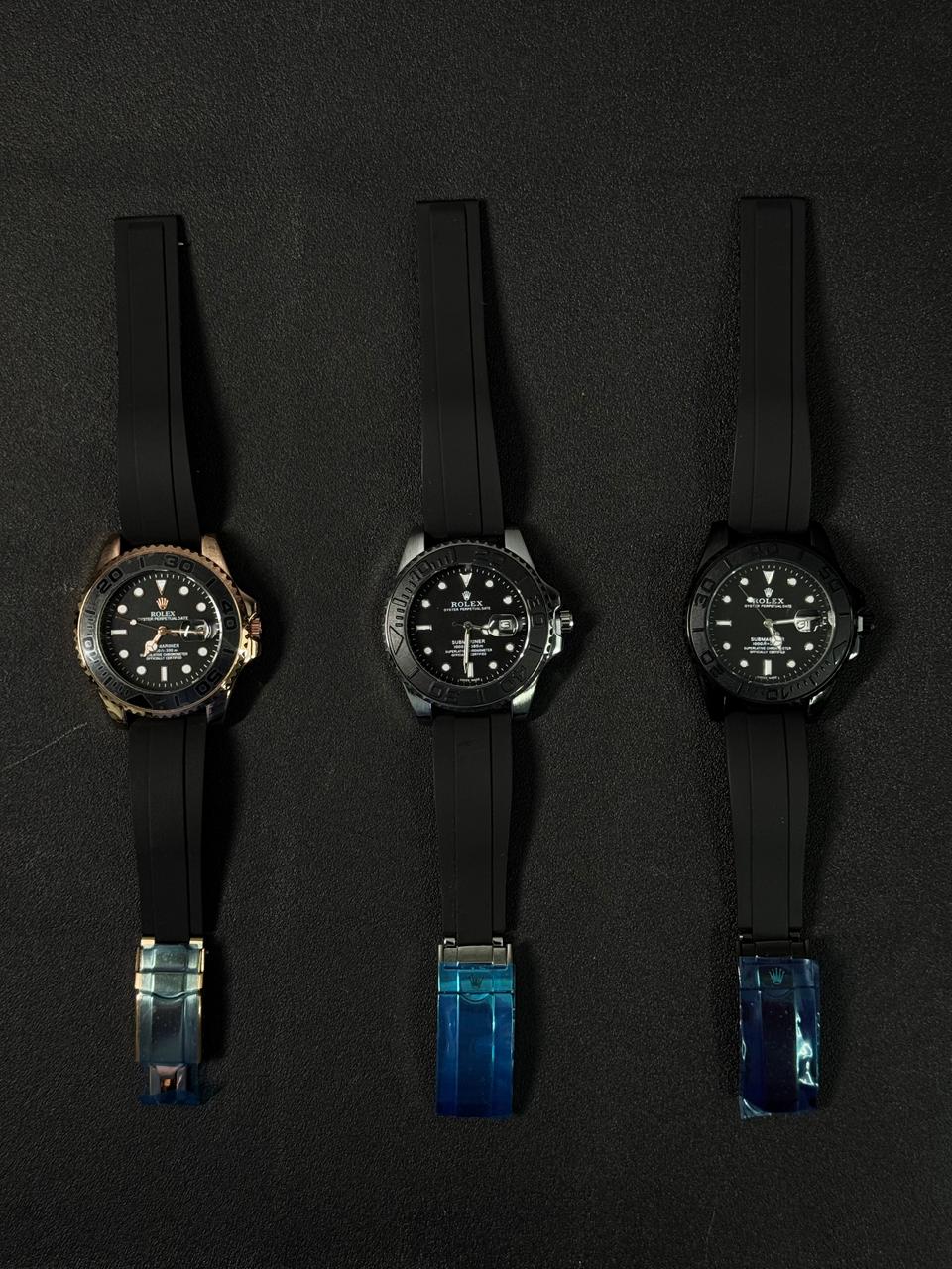 Luxury replica watch collection featuring automatic dive watches with black rubber Oysterflex-style straps on a dark background.