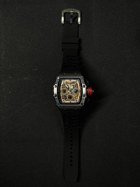 Luxury replica watch with a skeleton dial, a curved industrial silver case, a red-rimmed crown, and a black sports rubber band.