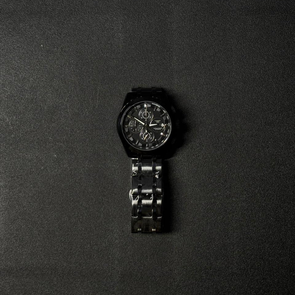Men's black replica watch with stainless steel bracelet and chronograph-inspired analog dial, luxury fashion wristwatch product image on dark surface