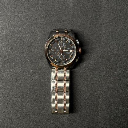 Replica chronograph watch with rose gold and silver stainless steel bracelet, black multi-dial analog display, luxury men's fashion wristwatch on dark textured background