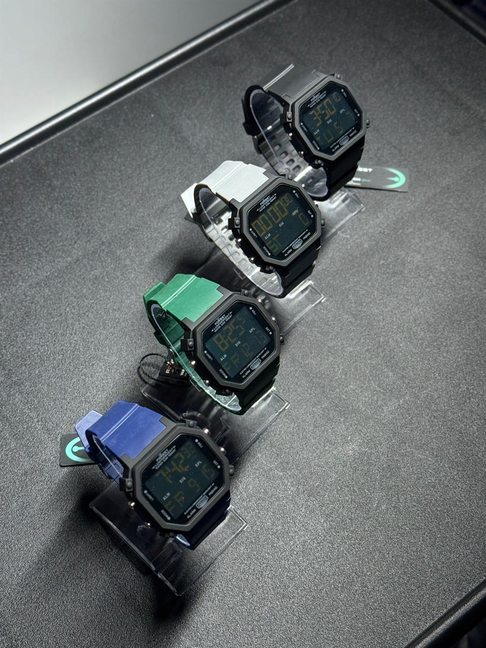 Replica digital wristwatch collection featuring black, grey, green and blue silicone straps with retro LED display and octagonal case design