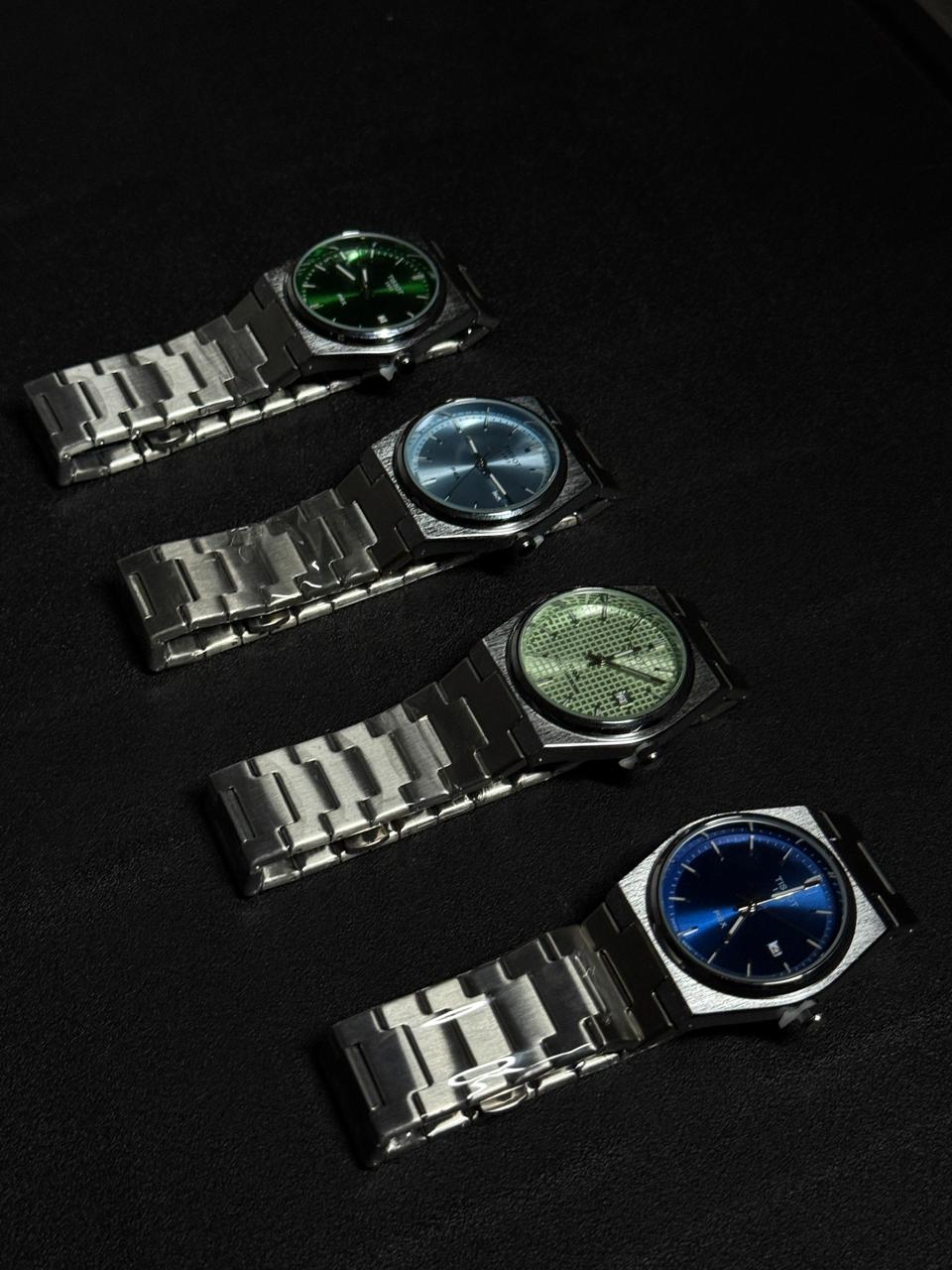 Luxury replica watch collection featuring green, blue, ice blue and textured green dial stainless steel watches displayed on black background