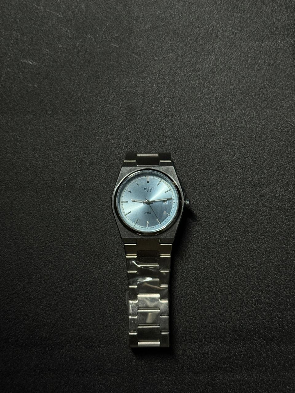 Ice blue dial replica watch with stainless steel bracelet, sunburst finish, date window and elegant luxury-inspired watch design