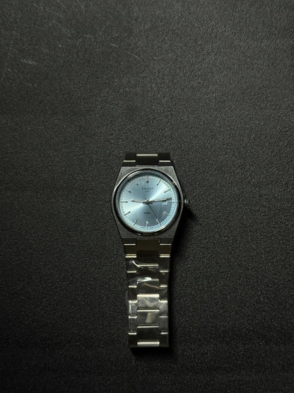 Ice blue dial replica watch with stainless steel bracelet, sunburst finish, date window and elegant luxury-inspired watch design