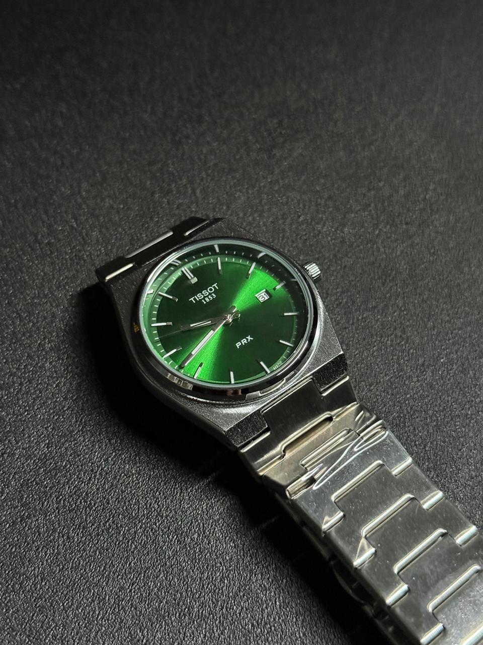 Replica watch with green sunburst dial, stainless steel integrated bracelet, date display window and luxury sports watch design on black textured background