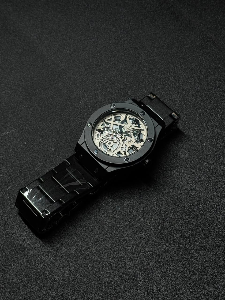 Replica watch with silver skeleton dial, black stainless steel band, premium men's analog wristwatch with open-work face