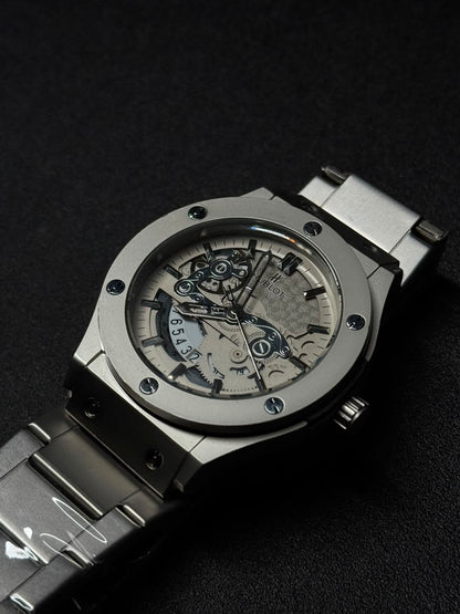 Luxury silver skeleton dial replica watch with stainless steel bracelet, transparent mechanical-style face and premium sports watch design.