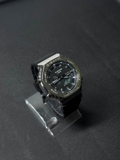 Black dial replica watch with analog digital display, octagonal bezel and black resin strap showcased on a dark studio background.