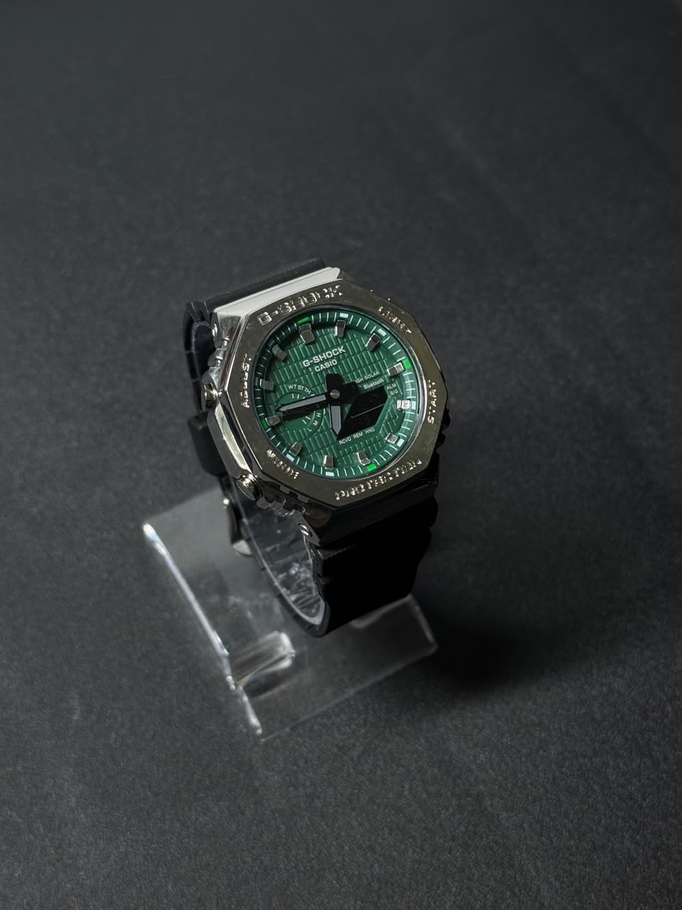 Green dial replica watch featuring octagonal stainless steel style bezel, black strap and luxury sports watch design on display stand.