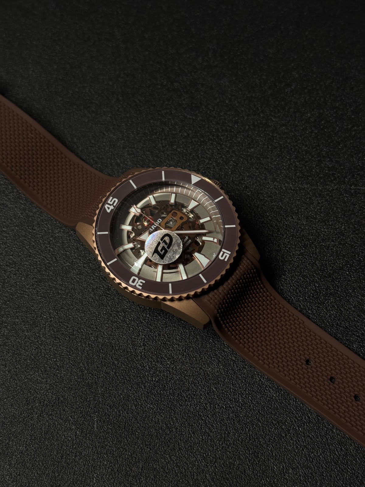 Brown luxury replica watch featuring a skeleton dial, textured rubber strap, and premium sport-style bezel in close-up view.