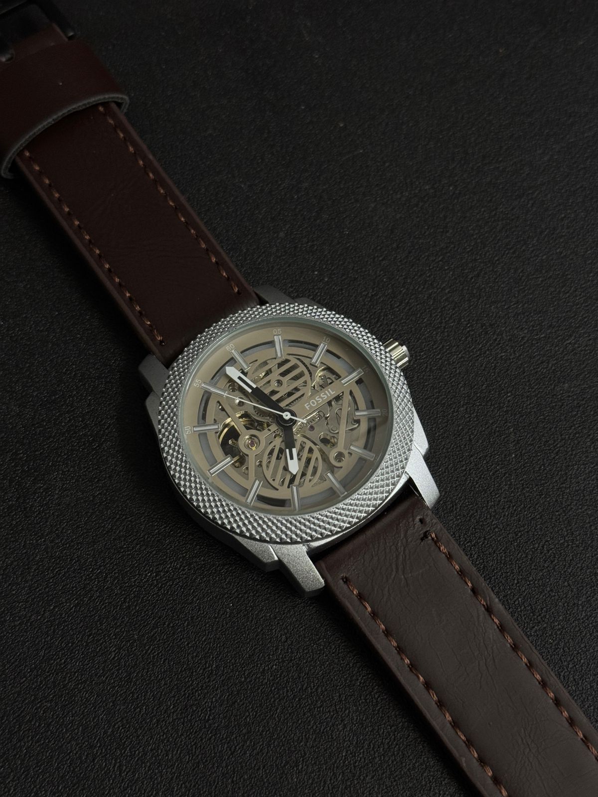 Premium replica watch with skeleton dial, silver textured bezel, brown leather strap, luxury-inspired men's analog wristwatch close-up