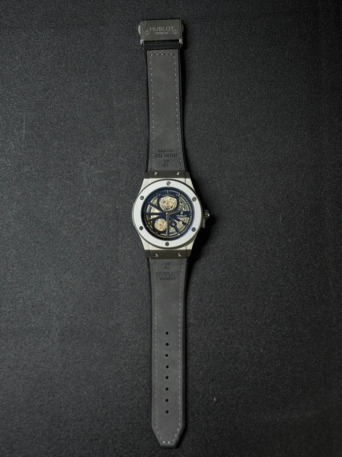 Replica watch with skeleton mechanical style dial, grey leather strap, elegant luxury design, full length product photography