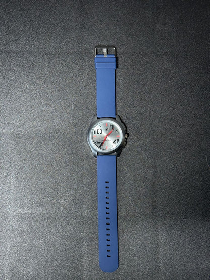 Replica Watch featuring blue silicone strap, silver brushed dial, black round case and red accent hands, stylish men's everyday analog wristwatch.