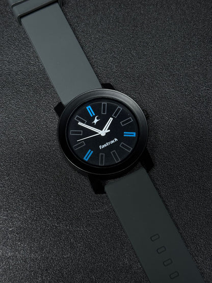Close-up of replica analog watch featuring grey silicone strap, black dial with blue hour markers, matte black case and contemporary design