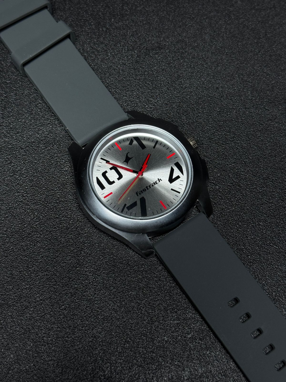 Replica Watch with grey silicone strap, silver sunburst dial, black case, red hands and modern analog display, premium men's casual wristwatch product photography.