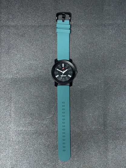 Replica Watch with teal silicone strap, black round dial, minimalist analog display and matte black case, modern casual wristwatch product photography