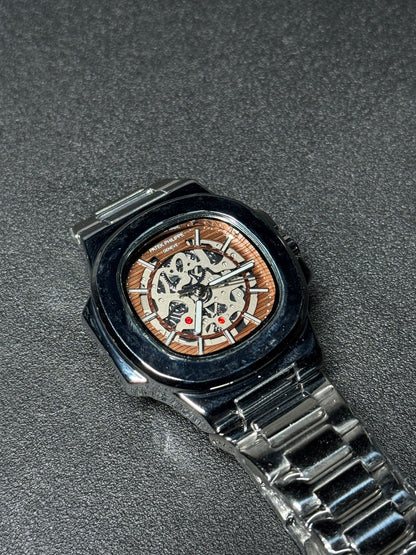Replica watch with brown skeleton dial, stainless steel bracelet, luxury automatic-style design, black bezel wristwatch product photography