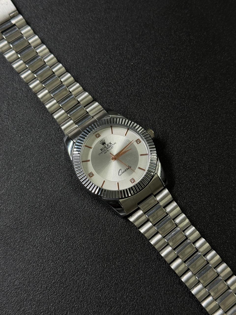 Silver wristwatch with a detailed face on a dark textured 