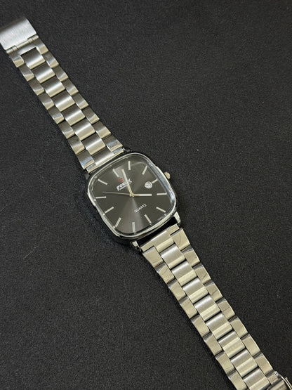 Silver wristwatch with a dark face on a black background
