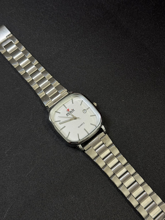 Silver wristwatch with a white face on a black background