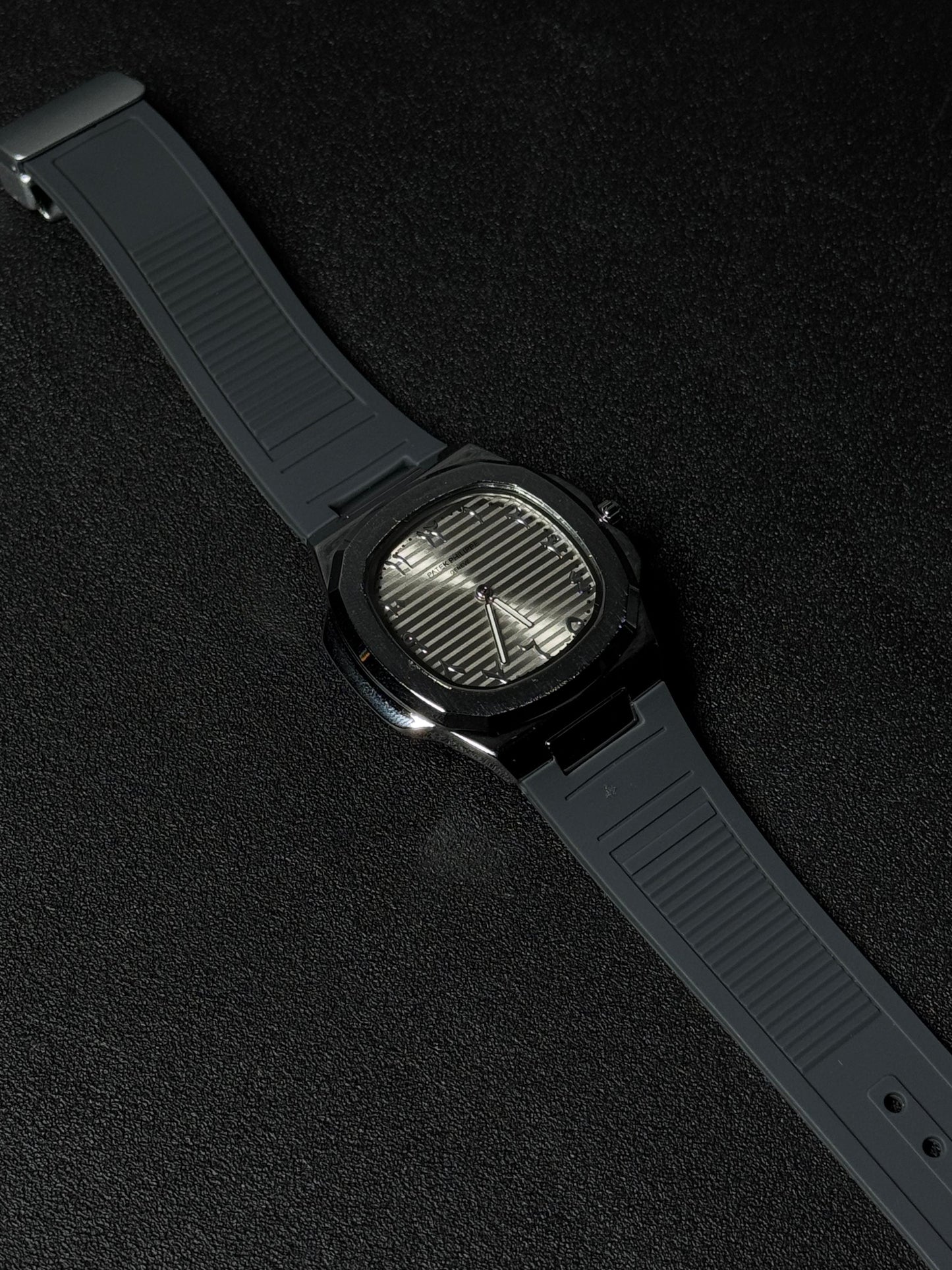 Black strap replica watch with textured dial, octagonal case design, luxury analog wristwatch and premium rubber strap on dark background