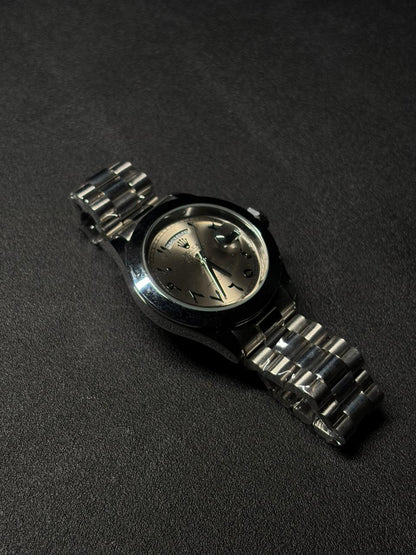 Replica silver dial day date watch with polished stainless steel case, Arabic numeral hour markers and premium metal bracelet close-up