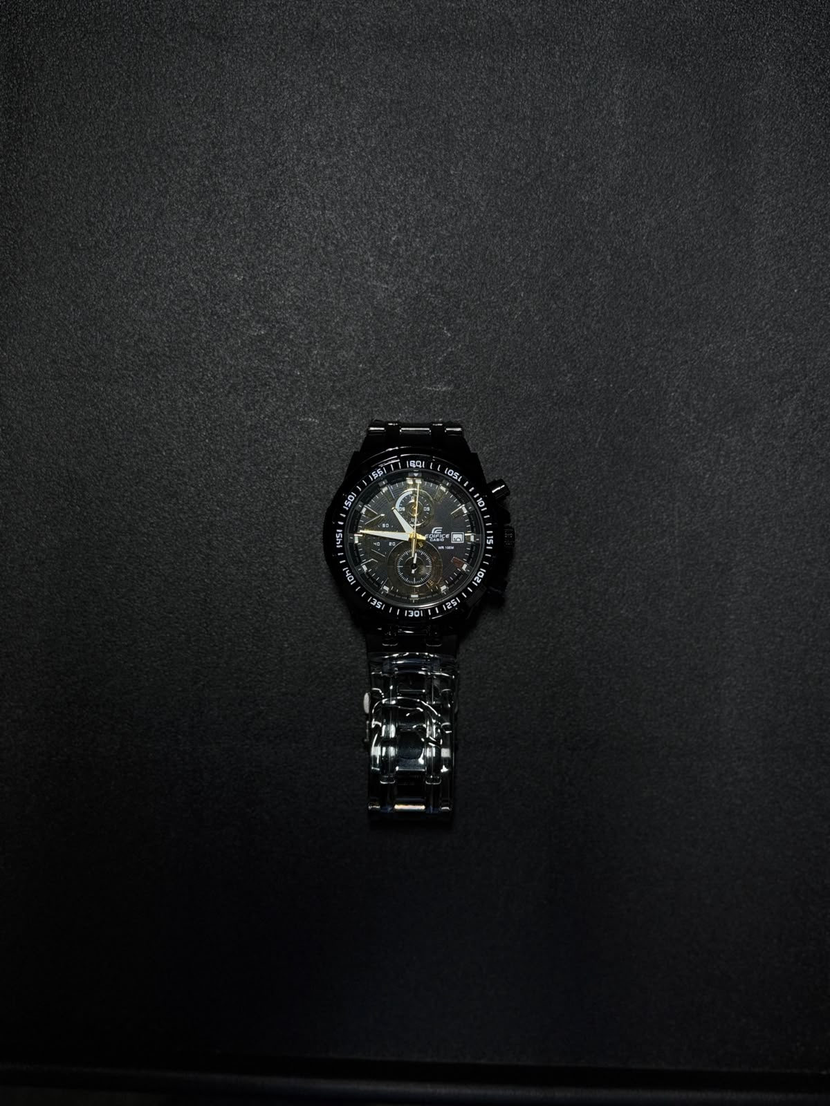 Black and gold replica men's watch with chronograph-style subdials, metal bracelet and modern luxury sports watch design.