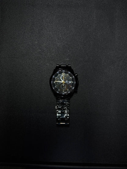 Black and gold replica men's watch with chronograph-style subdials, metal bracelet and modern luxury sports watch design.
