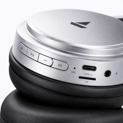 Premium silver over-ear wireless Bluetooth headphones with soft memory foam ear cushions, adjustable headband, built-in microphone, Type-C charging port, TF card slot, AUX input, and multifunction control buttons for immersive Hi-Fi stereo audio.