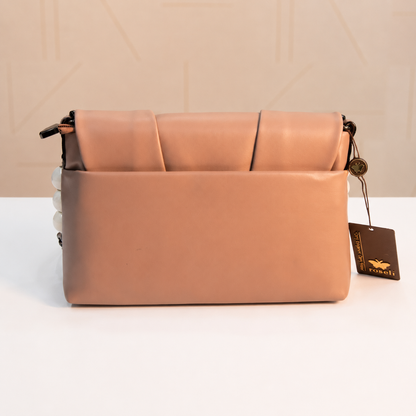 Back view of a nude beige women's shoulder bag with a rear slip pocket, smooth leather-look finish, decorative white beaded chain accents, and detachable shoulder strap.