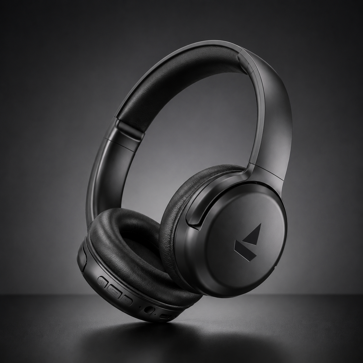 Black wireless over-ear Bluetooth headphones with cushioned earcups and matte finish on dark premium studio background