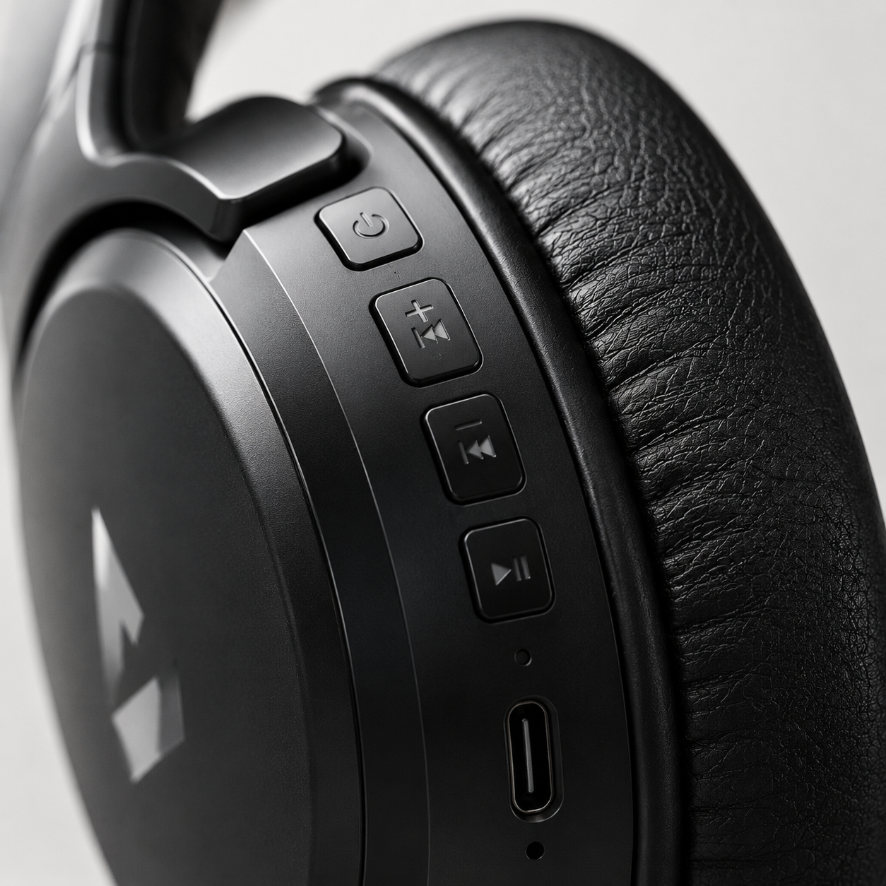 Close-up of wireless headphone control buttons and Type-C charging port with premium matte finish
