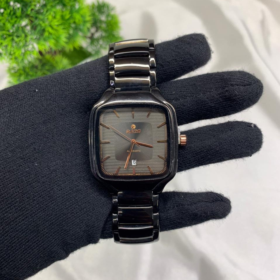 Replica watch for men with black stainless steel bracelet, square grey dial, rose gold hands, date display, luxury automatic style wristwatch close-up product photography