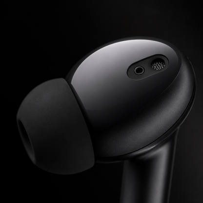 Close-up of wireless earbud featuring built-in microphone, ergonomic in-ear design, soft silicone ear tip, and premium matte black finish for calls and music.